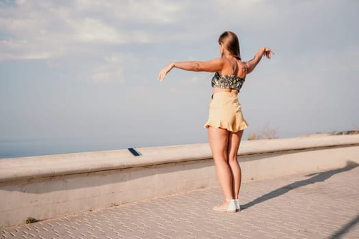 silhouette of a happy woman who dances, spins and raises her hands to the sky. A woman is enjoying a beautiful summer day.