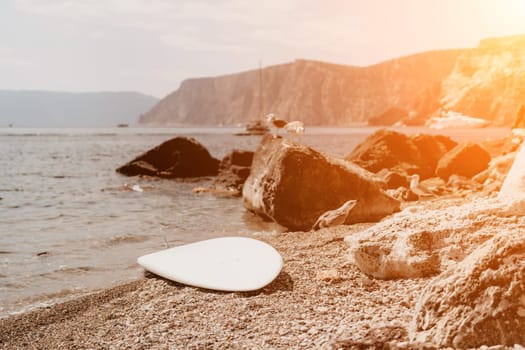 Woman travel sea. Young Happy woman in a long red dress posing on a beach near the sea on background of volcanic rocks, like in Iceland, sharing travel adventure journey