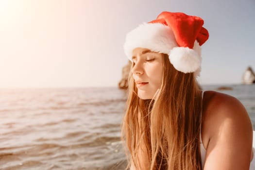 Close up shot of happy young caucasian woman looking at camera and smiling. Cute woman portrait in bikini posing on a volcanic rock high above the sea