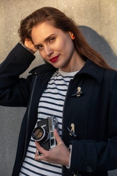 Lifestyle sunny fashion portrait of young stylish woman walking on street, with camera, smiling enjoy weekends, make a photo of her travel, old retro photocamera, vintage