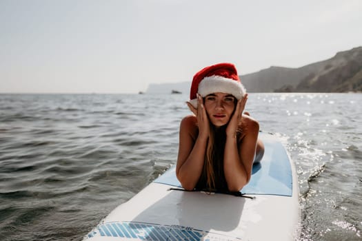 Close up shot of happy young caucasian woman looking at camera and smiling. Cute woman portrait in bikini posing on a volcanic rock high above the sea