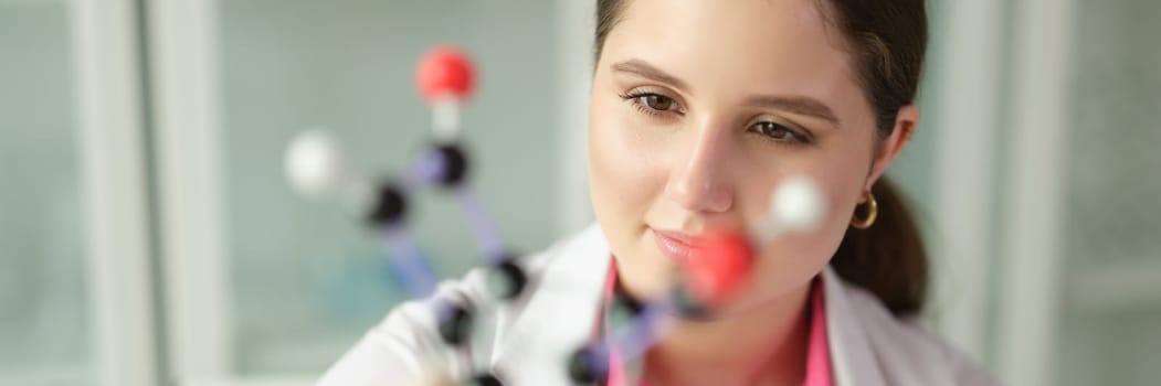 Woman scientist chemist in front of molecule in chemical laboratory. Genetic engineering concept