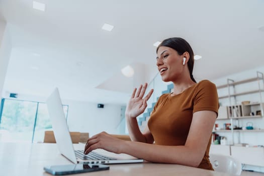 Woman sitting in living room using laptop looking at cam talk by video call with business friend relatives, head shot. Job interview answering questions