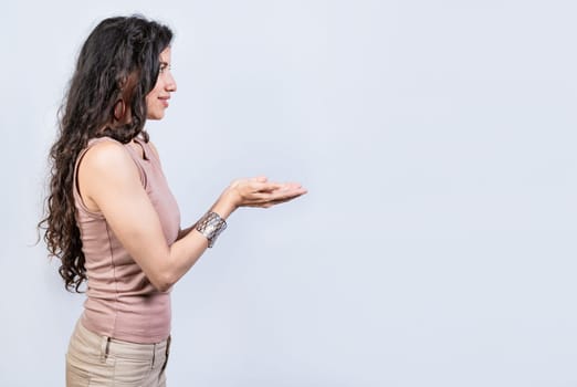 Smiling girl recommending a product with her hands, Young woman recommending an advertisement with the palm of her hands. Product recommendation concept