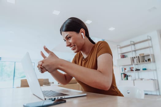 Woman sitting in living room using laptop looking at cam talk by video call with business friend relatives, head shot. Job interview answering questions