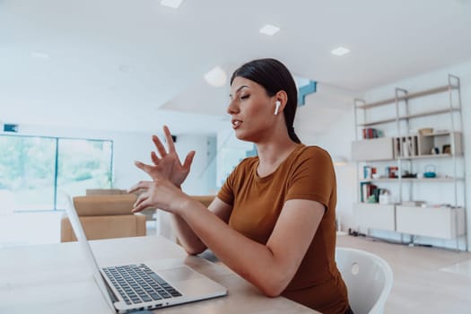 Woman sitting in living room using laptop looking at cam talk by video call with business friend relatives, head shot. Job interview answering questions