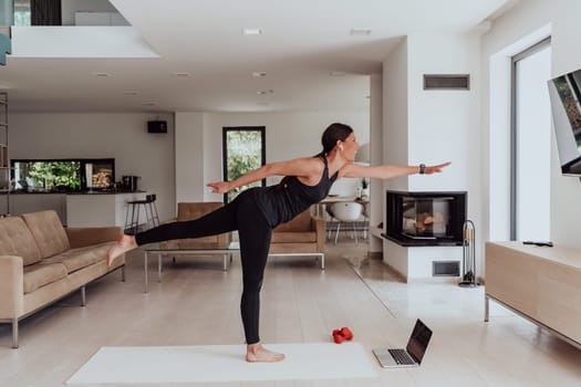 Young Beautiful Female Exercising, Stretching and Practising Yoga with Trainer via Video Call Conference in Bright Sunny House. Healthy Lifestyle, Wellbeing and Mindfulness Concept.