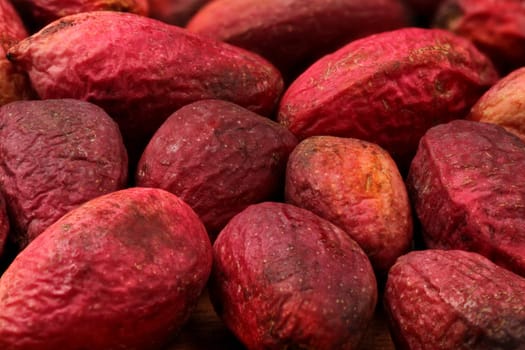 Closeup of raw red pistachios, nuts still under skin.