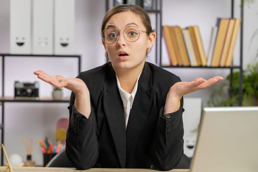 I dont know what to say. Confused business woman works on laptop at office workplace. Freelancer feeling embarrassed about ambiguous question, having doubts, no answer idea, being clueless, uncertain