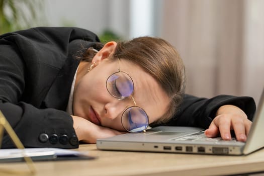 Bored sleepy Caucasian business woman in glasses worker working on laptop computer leaning on hand falling asleep at office. Exhausted tired freelancer workaholic girl. Employment occupation, workless