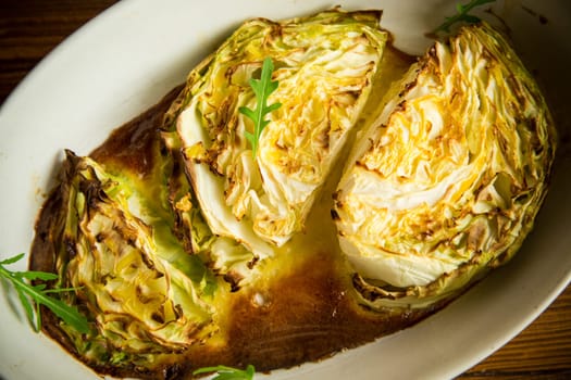 Young early cabbage baked in pieces in the oven, in a ceramic form.