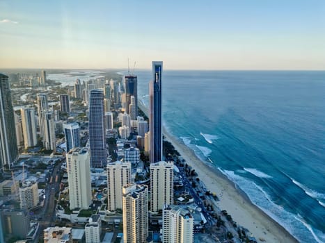 GOLD COAST, AUSTRALIA - APRIL 25, 2021: Aerial panorama view of High-rise building sky scrapers in Surfer Paradise beach and Pacific ocean landscape with Sunset light in the evening.