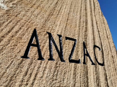 GOLD COAST, AUSTRALIA - AUGUST 16, 2020: Text 'ANZAC' on Surfers Paradise Esplanade ANZAC War Memorial Stone. This stone is located at Surfer Paradise beach. There is no body in the photo.