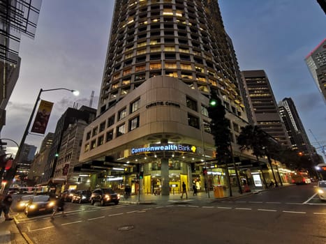 BRISBANE, AUSTRALIA - MAY 19, 2020: Commonwealth Bank of Australia (CBA) flagship headquarters office high-rise building in Brisbane Central Business District on Queen Street in Evening. There are people walk at intersection.
