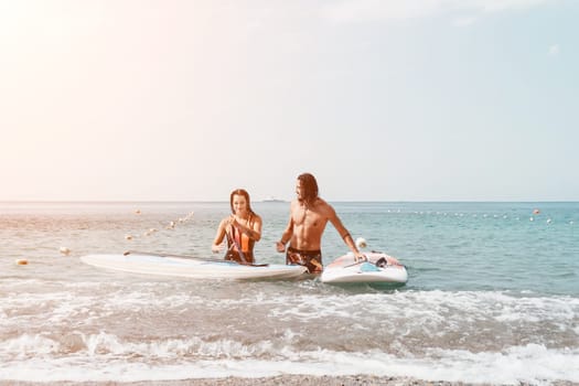 Woman man sea sup. Close up portrait of beautiful young caucasian woman with black hair and freckles looking at camera and smiling. Cute woman portrait in a pink bikini posing on sup board in the sea