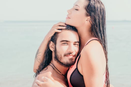 Close up shot of beautiful young caucasian woman with black hair and freckles looking at camera and smiling. Cute woman portrait in a pink bikini posing on a volcanic rock high above the sea