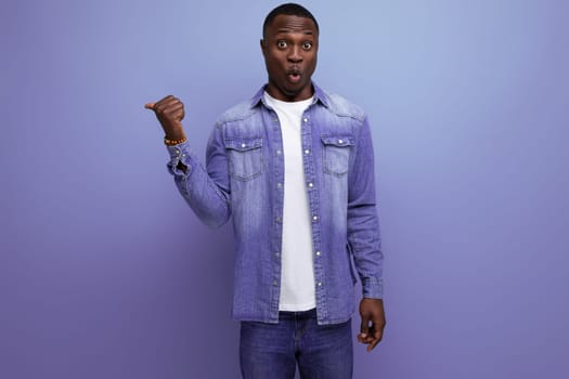 young handsome african guy in spring urban clothes pointing with his hands to the side on isolated background with copy space.