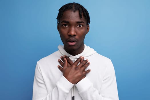 inspired charming man young brunette african man on blue isolated background.