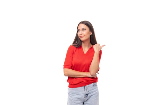 young caucasian female model with black straight hair dressed in a red t-shirt looks surprised on a white background with copy space.