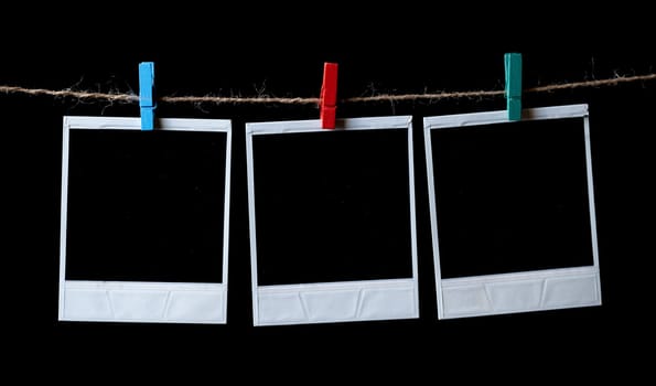 Blank square photo frames hanging on a clothesline. instant photo frames