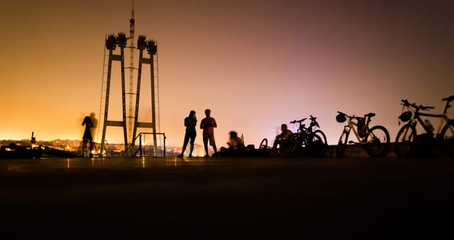 silhouette of group cyclists at sunset. people travel on bike. Cycling outdoor adventure. bikes with people night landscape.