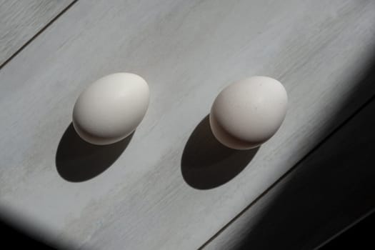 two white eggs on wood background. chicken eggs