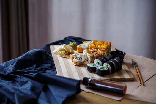 Set of traditional Japanese dishes. Sushi rolls, nigiri, raw salmon, rice, cream cheese, avocado, pickled ginger.