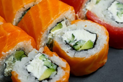 Japanese traditional food. Set of sushi rolls philadelphia with fresh salmon avocado and cream cheese and soy sauce