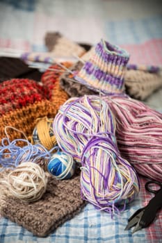 Colored threads, knitting needles and other items for hand knitting, on the bed .