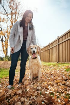 Happiest are those with pets in their lives. an attractive young woman having fun with her dog on an autumn day in a garden