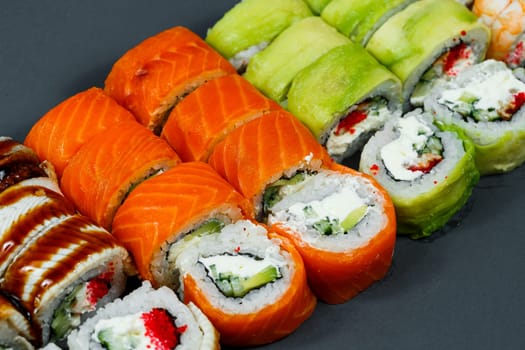 Sushi assorted. Sushi roll with avocado, cucumber. Sushi roll with salmon and caviar. Sushi roll with tuna and caviar. On a light background. Japanese food. View from above