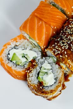Sushi assorted. Sushi roll with avocado, cucumber. Sushi roll with salmon and caviar. Sushi roll with tuna and caviar. On a light background. Japanese food. View from above
