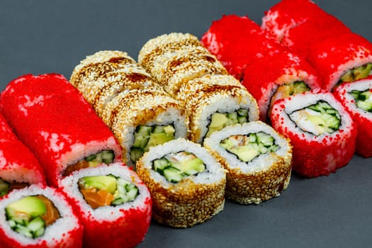 Sushi assorted. Sushi roll with avocado, cucumber. Sushi roll with salmon and caviar. Sushi roll with tuna and caviar. On a light background. Japanese food. View from above