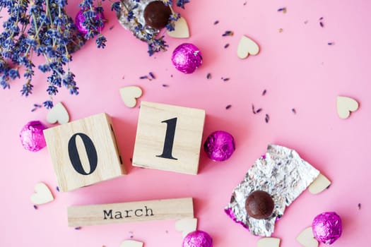 Wooden calendar with the date of March 1 on a pink background, a place for an inscription, The first day of spring, a dry branch of lavender