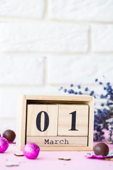 Wooden calendar with the date of March 1 on a pink background, a place for an inscription, The first day of spring, a dry branch of lavender