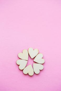 Valentine's day background. row of wooden hearts on a pink background. Valentine's day concept. Top view, place for an inscription, advertising