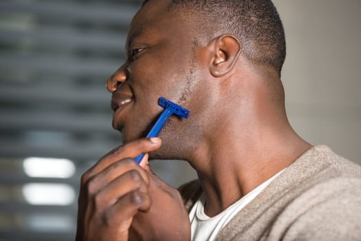 portrait of young man shaves with a shaving machine without using foam,