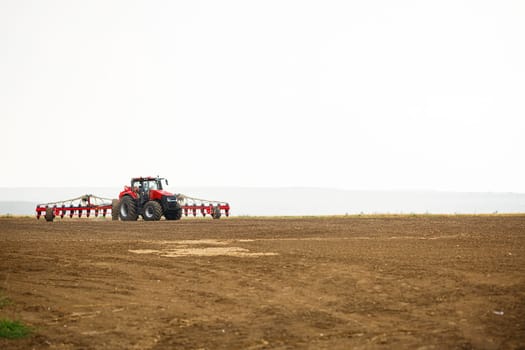 Large modern tractor for preparing the field after winter for sowing grain. Agricultural machinery