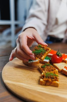 Slices of toasted bread and pate in female hands. Fresh croutons made of whole grain flour