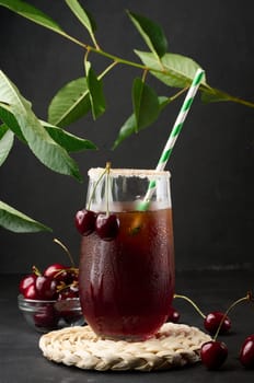 Cherry juice in a glass on a black background