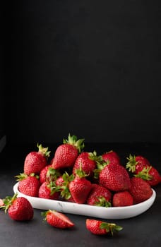 Ripe red strawberries on a black table