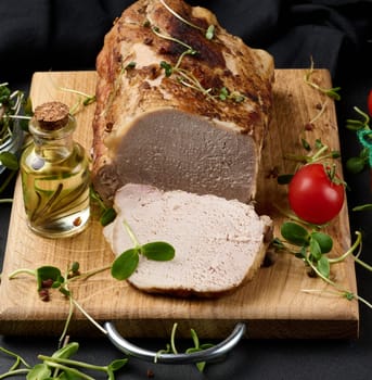 Baked piece of pork balyk on the table with spices. Tenderloin cut into pieces