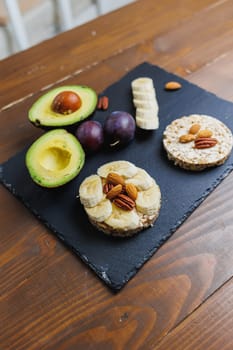 Vegan rice bread for breakfast with avocado and plums. Healthy Eating.