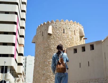 Woman tourist with a backpack on the Arab streets in the old part of Sharjah, UAE