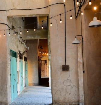 Narrow streets that create shade on a hot day in the old city of Dubai Creek and Bur district. Travel destinations and heritage village.