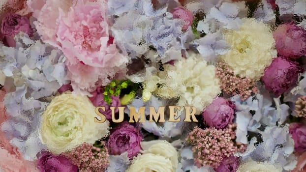 floral flowers background with the inscription summer with water droplets. wooden letters, close-up, top view, abstract