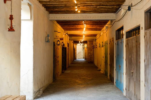 Narrow streets that create shade on a hot day in the old city of Dubai Creek and Bur district. Travel destinations and heritage village.