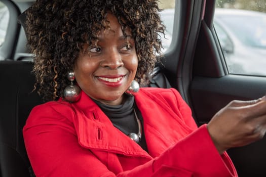 Pretty african woman passenger in a car doing makeup while standing in a traffic jam, concept a modern married business woman with children saves time, High quality photo