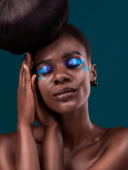 Face, beauty and cosmetics with an african woman in studio on a blue background for hair or cosmetics. Eyes closed, haircare and fashion with an attractive young female model at the salon for style.