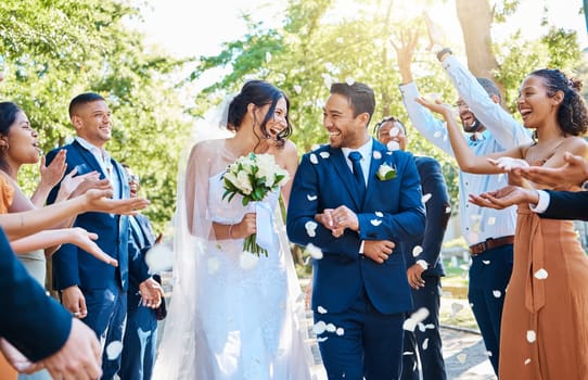 Happy, wedding ceremony and couple walking with petals and guests throw in celebration of romance. Romantic, flowers and bride with bouquet and groom with crowd celebrating at outdoor marriage event